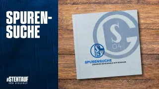 Das Buch Spurensuchen auf einem Holzhintergrund