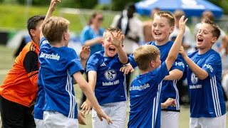 Kinder, die Fußball spielen und sich freuen.