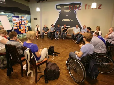 Die AG für Alle sitzt im Kreis vor einem Flipchart.