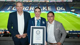 Lena Kuhlmann, Senior Adjudicator bei Guinness World Records, bei der Übergabe der Urkunde mit dem Spielfeld im Hintergrund.