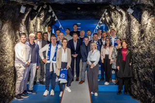 Die Zukunftsschmiede 04 steht in dem Spielertunnel der VELTINS-Arena, der einen Bergbauschacht gleicht, mit schwarzer Kohle an den Wänden, zusammen.