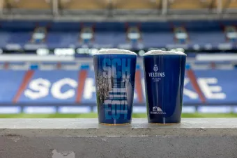 Das Bild zeigt zwei Mehrwegbecher in der Veltins-Arena.