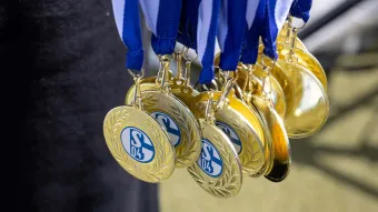Mehrere goldene Medaillen mit dem Schalke-Logo