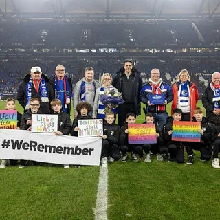 Ehrung des SSV Buer auf dem Rasen in der Veltins-Arena mit Schülern, die kleine und große Banner hochhalten vor der Tribüne.