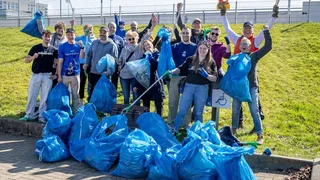 Die Beteiligten der Müllsammelaktion präsentieren volle Müllsäcke.