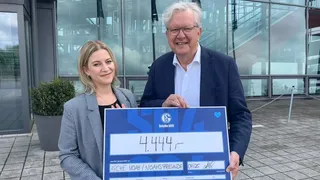 Natascha Schwenzfeier und Wolfgang Heinberg bei der symbolischen Scheckübergabe von 4.444 € an das Kinderhospiz Arche Noah im Rahmen der Initiative „Schalke hilft!“.